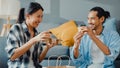 Happy asian young attractive couple man and woman sit at new home drink coffee relax and talk smile with carton package box Royalty Free Stock Photo