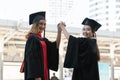 Happy Asian young beautiful graduate students with master and bachelor University degree with black board cap with red tassels Royalty Free Stock Photo