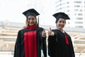 Happy Asian young beautiful graduate students with master and bachelor University degree with black board cap with red tassels Royalty Free Stock Photo
