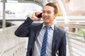 Happy asian young businessman using mobile phone. Man talking to clients via cell phone have a smile on his face in the city Royalty Free Stock Photo