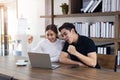 Happy Asian young Businesswoman and Business man working laptop computer on wood desk in Home office Royalty Free Stock Photo