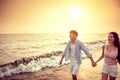 Happy asian young couple walking on the beach at sunset Royalty Free Stock Photo