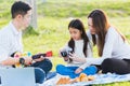 Family father, mother and child having fun and enjoying outdoor together sitting on the grass party with shooting photos Royalty Free Stock Photo