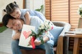 Happy Asian young father getting bunch of flowers and handmade card congratulations on Fathers Day from little cute daughter Royalty Free Stock Photo