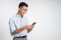 happy asian young man looking at the screen of a mobile phone Royalty Free Stock Photo