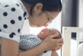 Happy Asian Young mother playing with little baby. Loving Female embracing her son in her hand Royalty Free Stock Photo