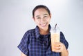 Happy Asian young woman is drinking Thai tea with milk. Popular beverage in Asia Royalty Free Stock Photo