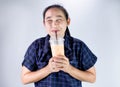 Happy Asian young woman is drinking Thai tea with milk. Popular beverage in Asia Royalty Free Stock Photo