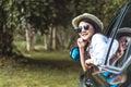 Happy Asian young woman enjoying a ride in a car with hand greeting Royalty Free Stock Photo