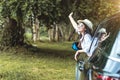 Happy Asian young woman enjoying a ride in a car with hand greeting Royalty Free Stock Photo