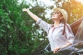 Happy Asian young woman enjoying a ride in a car with hand greeting. Royalty Free Stock Photo