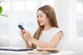 Happy asian young woman smile using smartphone surfing internet and enjoy with social media or online shopping at home. Modern Royalty Free Stock Photo