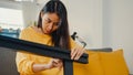 Happy asian young woman unpacking box and reading the instructions to assemble new furniture decorate house build table with