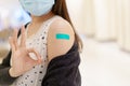 Beautiful Asian woman showing a vaccination injection point at her arm. Royalty Free Stock Photo