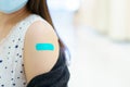 Beautiful Asian woman showing a vaccination injection point at her arm. Royalty Free Stock Photo