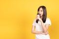 Happy asian young woman wearing white t-shirt standing and holding a coffee