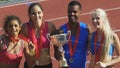 Happy athletes proudly demonstrating their cups and medals, honored awards