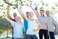 Happy athletic group holding up bottle of water