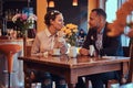 Happy attractive African-American couple in love having a great time together in a restaurant at their dating. A Royalty Free Stock Photo