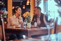 Happy attractive African-American couple in love having a great time together in a restaurant at their dating. A Royalty Free Stock Photo