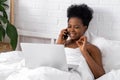 Happy attractive african american girl working office work remotely, Black woman using laptop computer and phone sitting Royalty Free Stock Photo