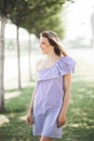 Happy and attractive beautiful artistic young girl in dress in summer garden posing for camera