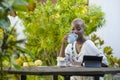 Happy attractive black afro American woman working with tablet outdoors at cafe relaxed drinking tea or coffee in digital nomad su