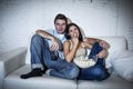 Happy attractive couple having fun at home enjoying watching television relaxed Royalty Free Stock Photo