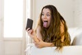 Happy attractive girl playing on home couch taking selfie portrait with mobile phone having fun