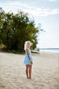 Happy attractive girl relaxing by the sea. Young beautiful woman in blue dress posing outdoors. Female resting at beach in summer Royalty Free Stock Photo