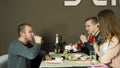 Happy and attractive group of friends chatting and eating sushi together in a sushi bar