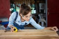 Happy attractive hardworking middle aged professional female carpenter worker looking and choosing wood in the workshop