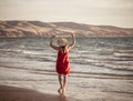 Woman in red with arms outstretched by the sea at sunrise enjoying freedom and outdoors life Royalty Free Stock Photo