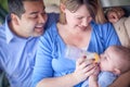 Happy Attractive Mixed Race Couple Bottle Feeding Their Baby Royalty Free Stock Photo