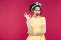 Happy attractive pinup girl in yellow dress showing ok sign Royalty Free Stock Photo