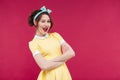 Happy attractive pinup girl in yellow dress standing and winking Royalty Free Stock Photo