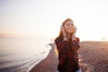 Happy attractive red-haired girl is enjoying favorite music on walk. Beautiful young woman in shirt uses headphones Royalty Free Stock Photo