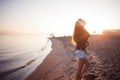 Happy attractive red-haired girl is enjoying music on walk. Beautiful young woman in shirt uses headphones, soft focus Royalty Free Stock Photo