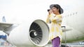 A happy senior Asian female tourist taking pictures with her film camera at the airport Royalty Free Stock Photo
