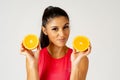 Happy attractive sporty woman holding glass of fresh orange juice and orange fruit Royalty Free Stock Photo