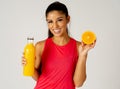 Happy attractive sporty woman holding glass of fresh orange juice and orange fruit Royalty Free Stock Photo