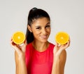 Happy attractive sporty woman holding glass of fresh orange juice and orange fruit Royalty Free Stock Photo