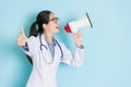 Happy attractive woman doctor using loudspeaker