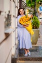 attractive woman with huge bouquet of decorative sunflowers at the city