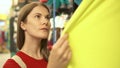 Happy attractive woman in red t-shirt shopping in mall buying clothes. Consumerism shopaholism concept