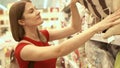 Happy attractive woman in red t-shirt shopping in mall buying pillow. Consumerism shopaholism concept