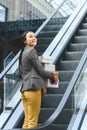 happy attractive woman standing on escalator in mall