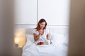 Happy attractive woman woke up in the morning in bed. Woman having breakfast in the hotel room, Woman having breakfast in bed with Royalty Free Stock Photo