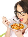 Happy Attractive Young Hispanic Woman Eating a Plate of Tomato and Basil Penne Pasta Royalty Free Stock Photo