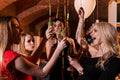 Happy attractive young women having birthday party laughing, dancing, singing, enjoying the night in stylish restaurant Royalty Free Stock Photo